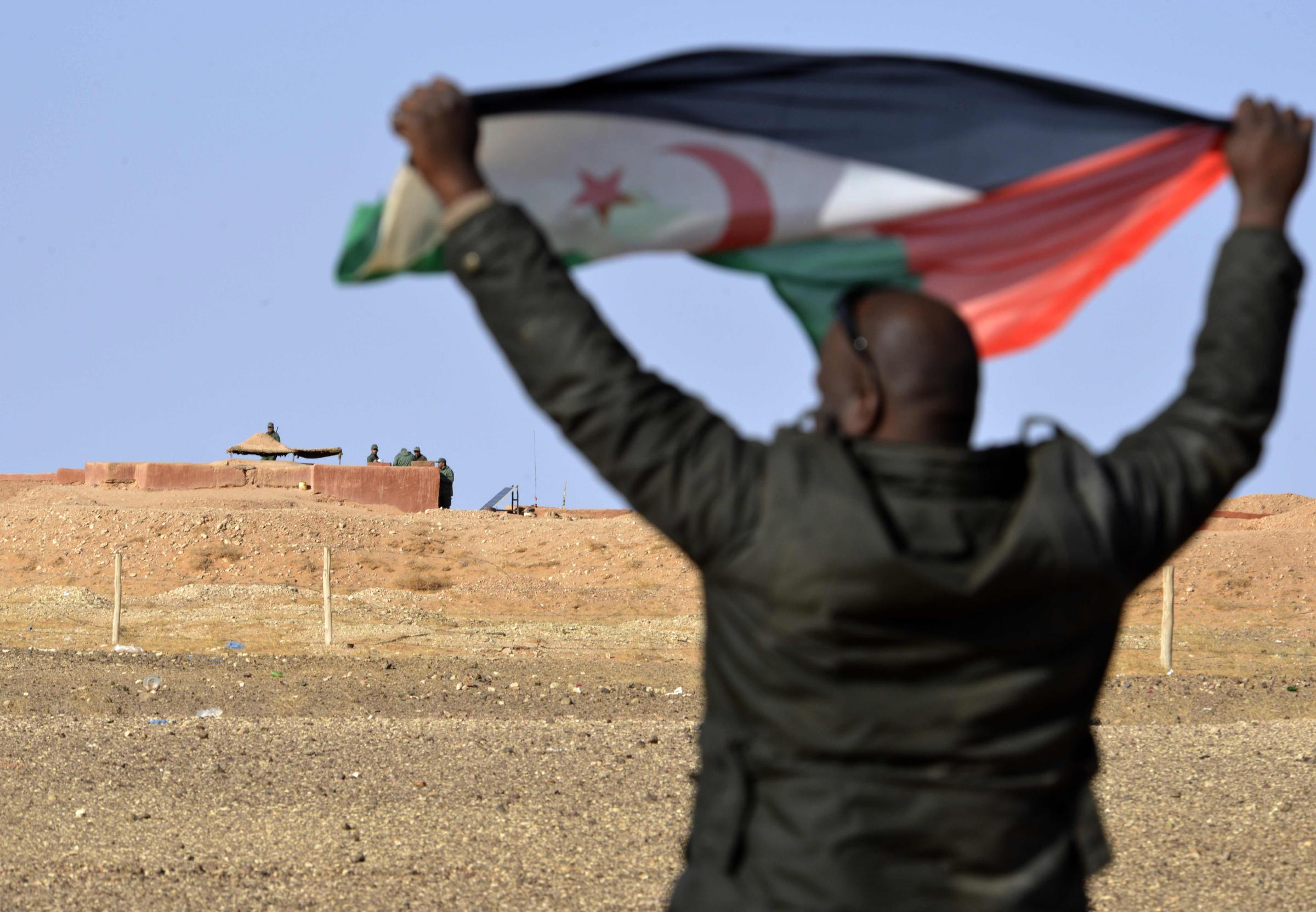 Un uomo saharawi con una bandiera del Fronte Polisario (LaPresse)