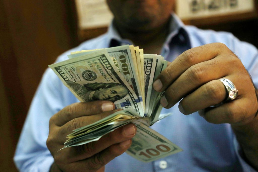 An employee counts money in a money exchange office in downtown Cairo, Egypt