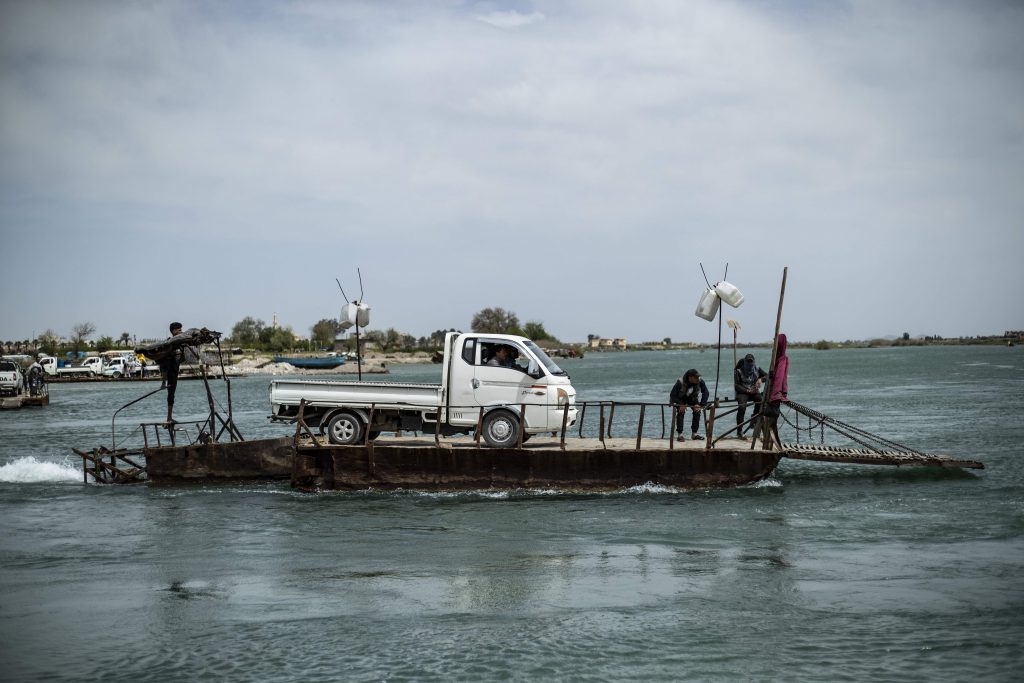 A vehicle is transported on a platform on the Euphrates river in the northern Syrian city of Raqa, the former Syrian capital of the Islamic State Delil Souleiman/AFP)