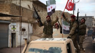 I miliziani dell'Esercito siriano libero, appoggiato dalla Turchia, innalzano la bandiera di Ankara a Manbij il 29 dicembre del 2018 Nazeer Al-Khatib/Afp via LaPresse)