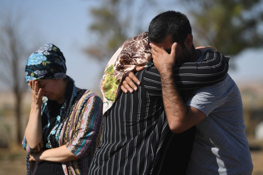 Curdi in lacrime davanti ai morti provocati dall'avanzata turca (LaPresse)