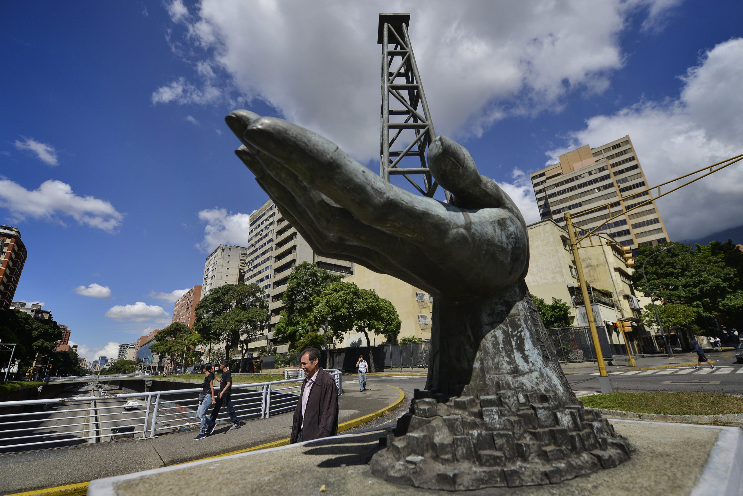 Una scultura di una mano che regge una struttura di pozzi petroliferi fuori dalla compagnia petrolifera statale venezuelana Pdvsa a Caracas (LaPresse)
