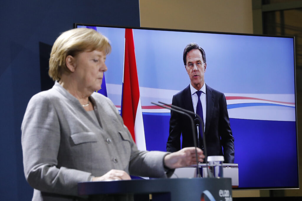 German Chancellor Angela Merkel listens to Netherlands Prime Minister Mark Rutte during a virtual news conference