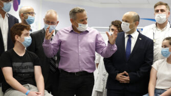 Israeli Prime Minister Naftali Bennett, center right, listens as Health Minister Nitzan Horowitz speaks during his visit to a Maccabi healthcare maintenance organisation in Israel