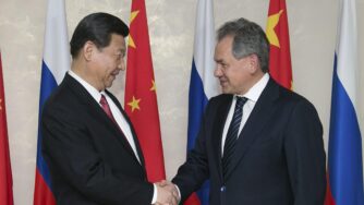 Russian Defense Minister Sergei Shoigu (R) and Chinese President Xi Jinping (L) shake hands prior to their talks in Moscow, Russia