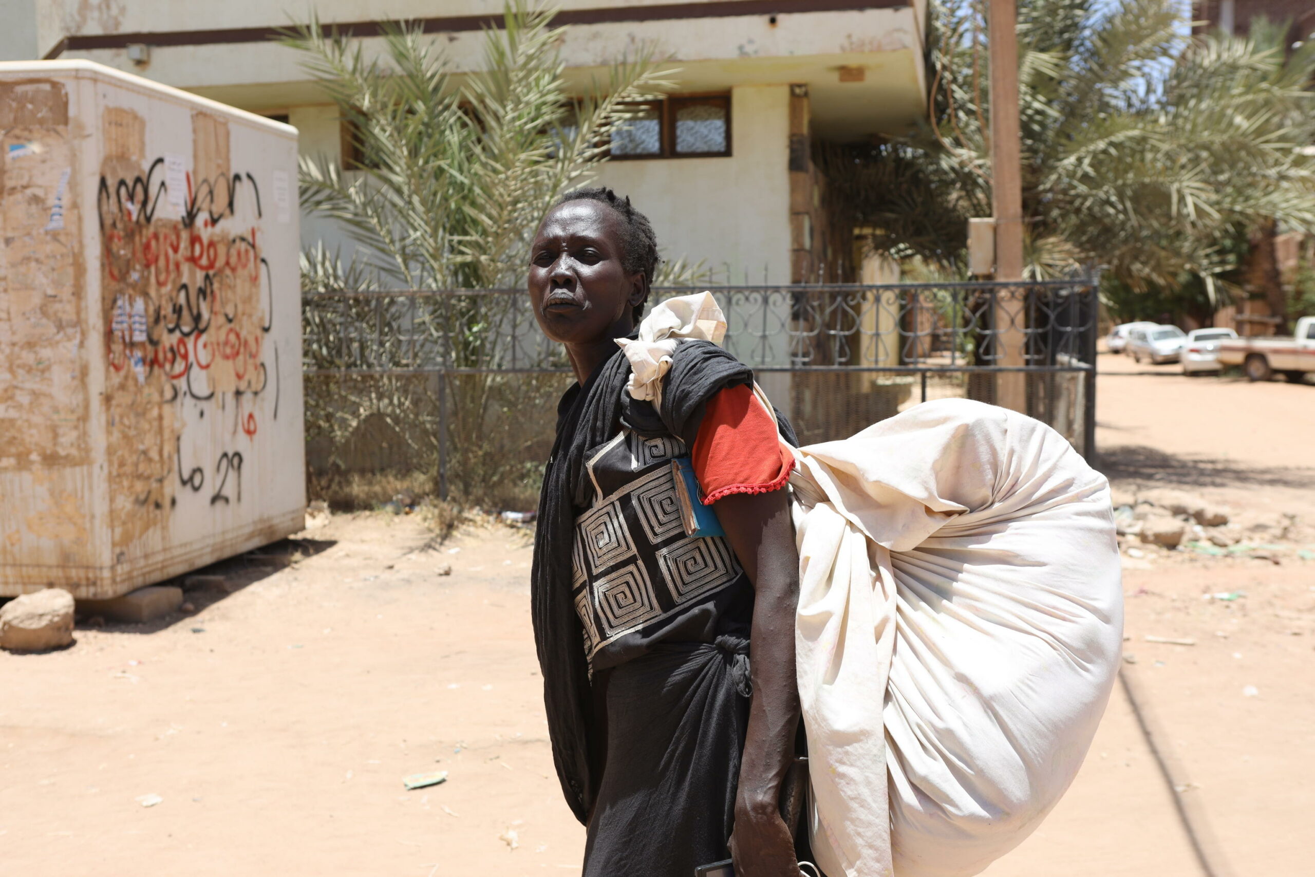 A Sudanese woman carries her belongings on a street in Khartoum, Sudan