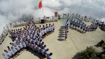 Aerial view of Chinese navy veterans standing to form the flag of the People's Liberation Army