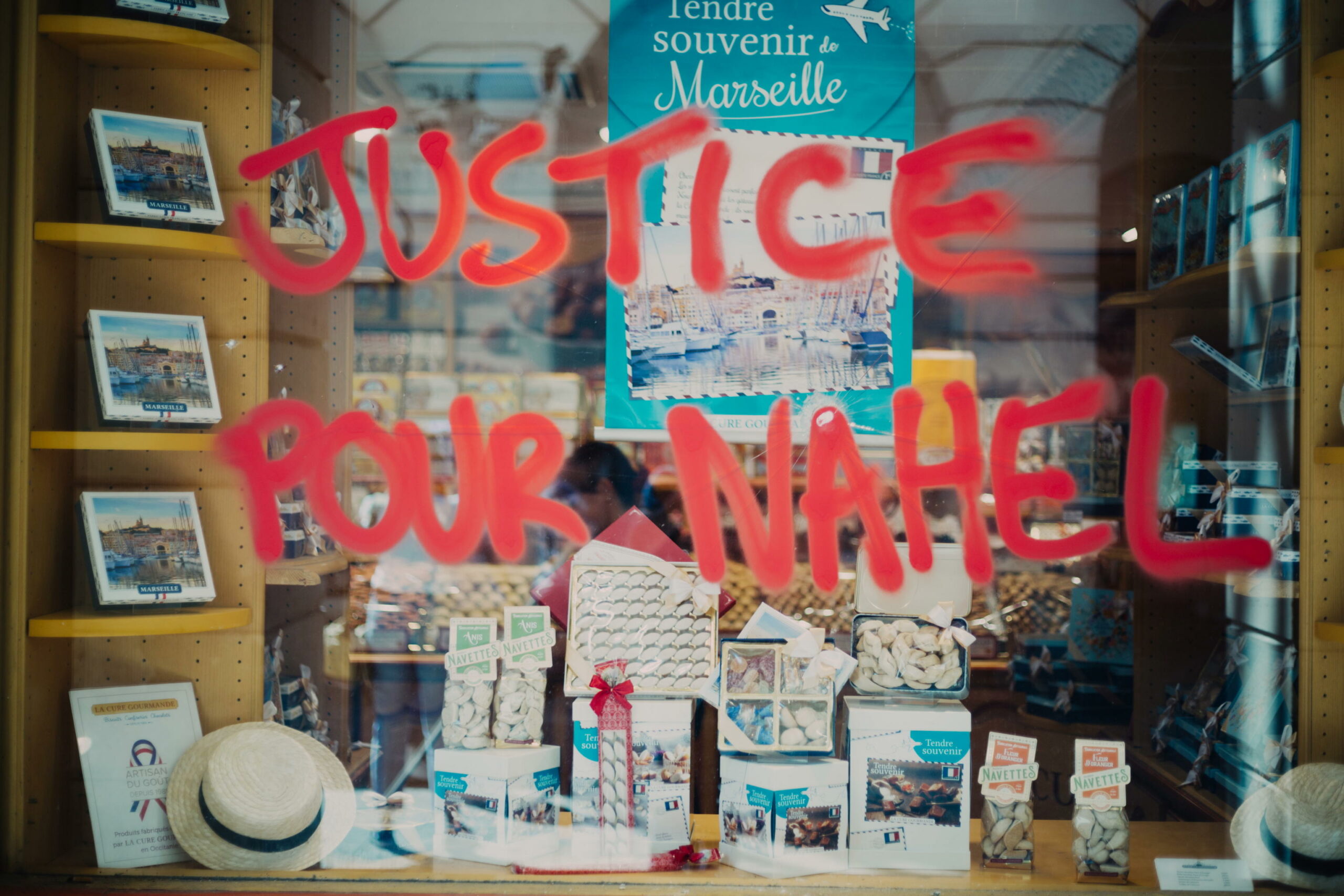 "Giustizia per Nahel", così recita una scritta su una vetrina colpita dalle devastazioni in Francia di questi giorni